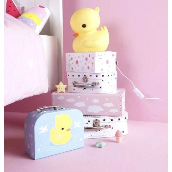 Little Duck Lamp by A Little Lovely Company, yellow duck atop pastel stacked boxes in a pink nursery.