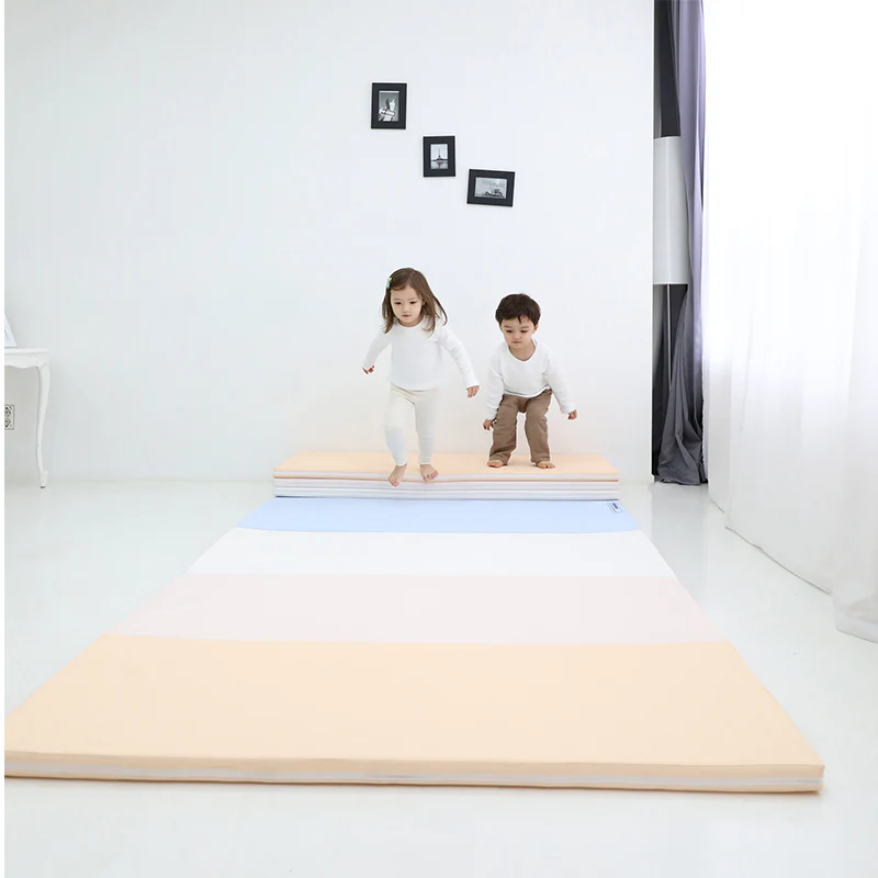 Baby Care Premium Tumbling Folding Mat Large Pastel Blue; toddlers jump on pastel layered mats in a bright room.