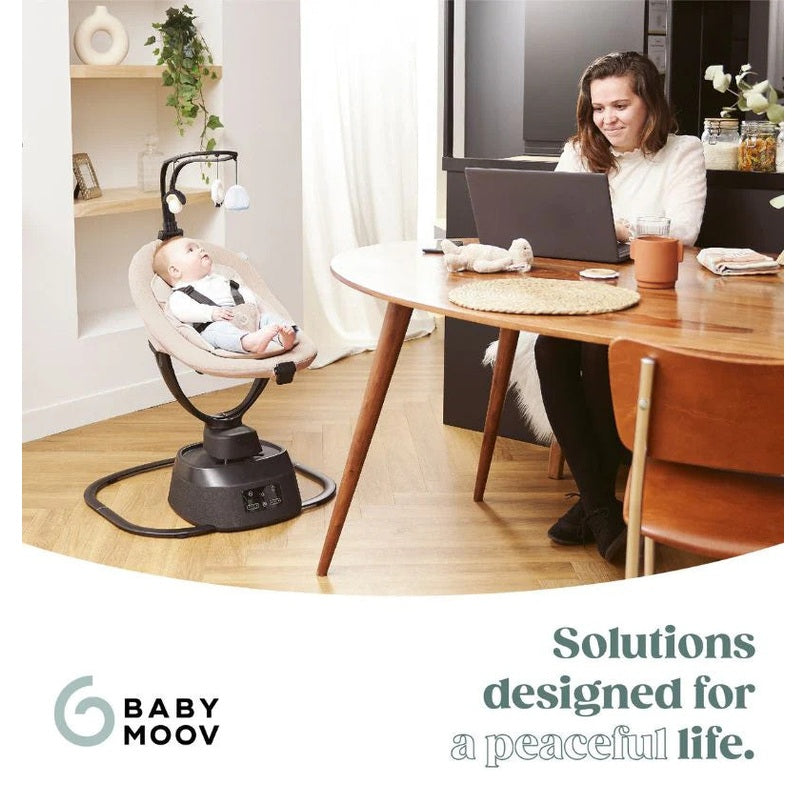Babymoov Baby Swing Swoon Evolution Connect Mocca with baby resting in swing beside a dining table setup