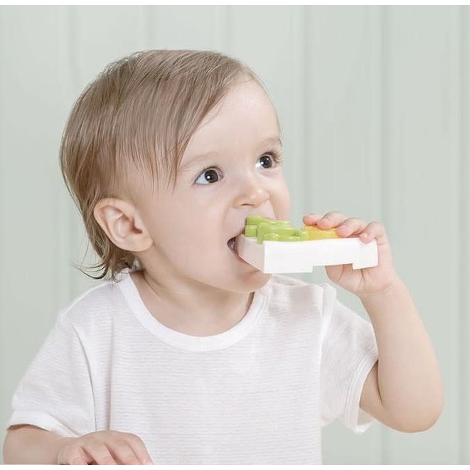 BC Babycare Little Cooker Pizza Set toy; toddler holding a white cooker base with colorful green and orange pieces