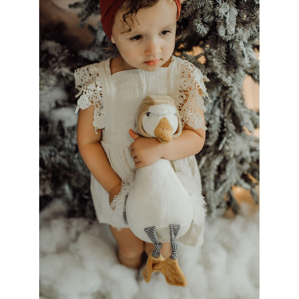 Avery 12in Snow Goose plush by Bunnies By The Bay held by a toddler in a white lace dress