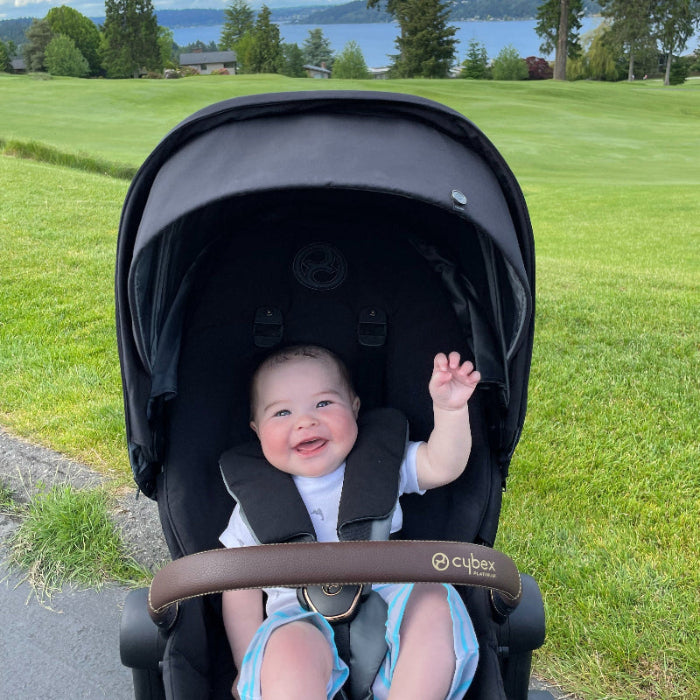 CYBEX e-Priam Chrome Frame stroller with Lux Carry Cot in Deep Black; smiling