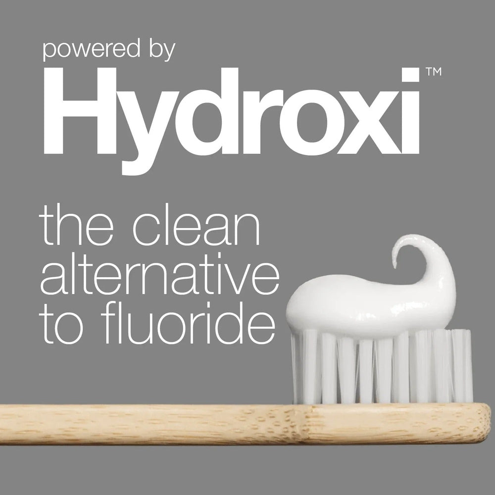 DAVIDS Toothpaste Sensitive & Whitening Fluoride Free Peppermint on a white toothbrush against gray backdrop