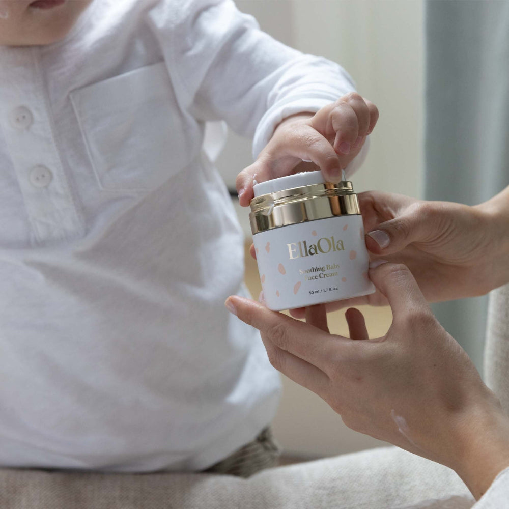 EllaOla Fragrance Free Moisturizing Baby Face Cream 50ml; caregiver applies cream to baby's cheek.
