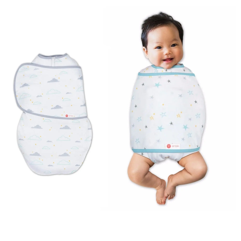 Embe Transitional SwaddleOut baby swaddle with light-blue trim and stars, snugly wrapped around a smiling infant.