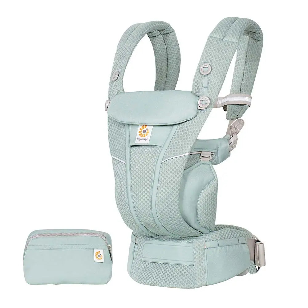 Ergobaby Omni Breeze baby carrier in light blue worn to show padded shoulder straps and adjustable waist belt, with compact accessory pouch.