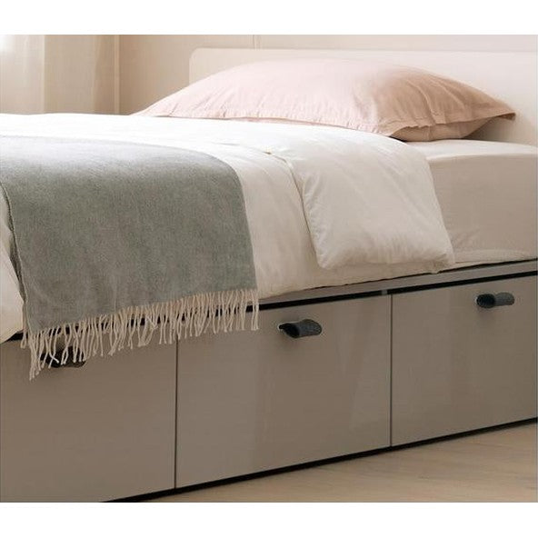 ILOOM Tiede Bed storage toddler bed with white frame and gray throw blanket and built-in drawers
