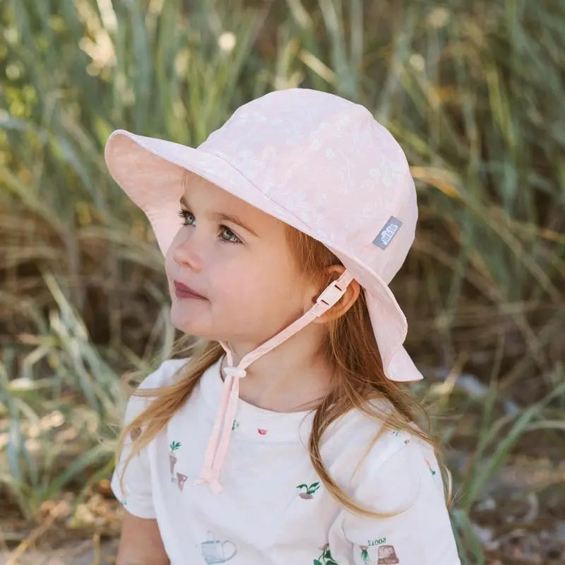 Jan & Jul Cotton Floppy Hat Prairie Flowers worn by a toddler girl; pale pink with chin strap tied under her chin.