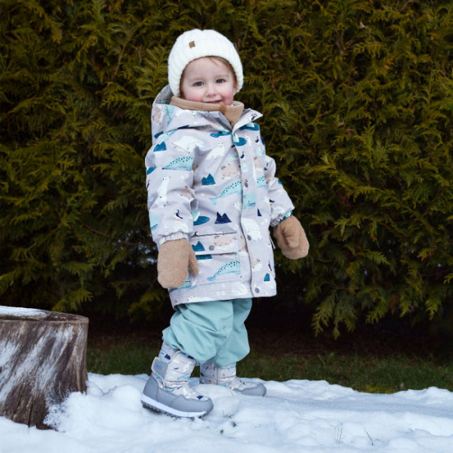 JAN & JUL fleece mittens Soft Brown worn by a toddler as she plays in the snow in a warm coat.