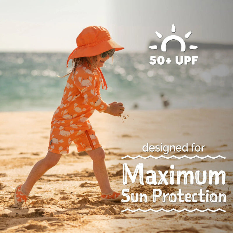 Jan & Jul Kids One Piece UV Sun Suit Crabby Crab in orange; toddler on sunny beach wearing UPF 50+ swimwear.