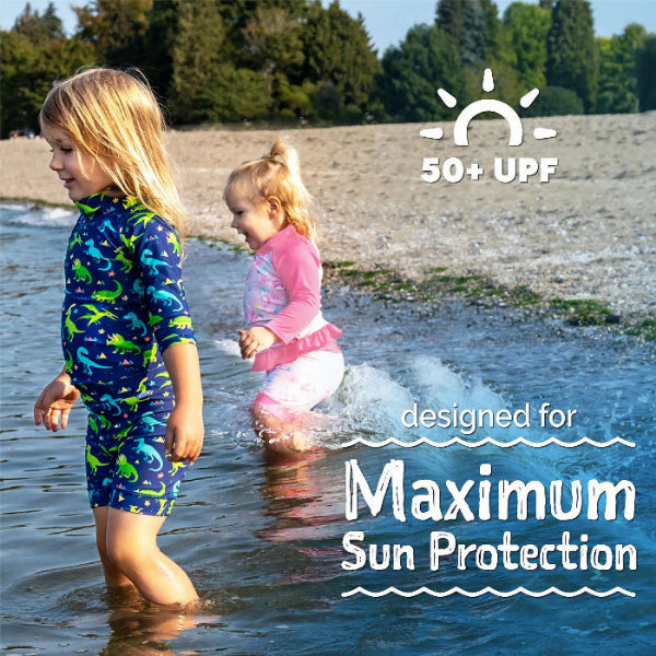 Jan & Jul Kids UV Rashguard Set Dinoland; blue dinosaur-print 2-piece swimwear for toddlers, two kids wading in shallow beach water, 50+ UPF
