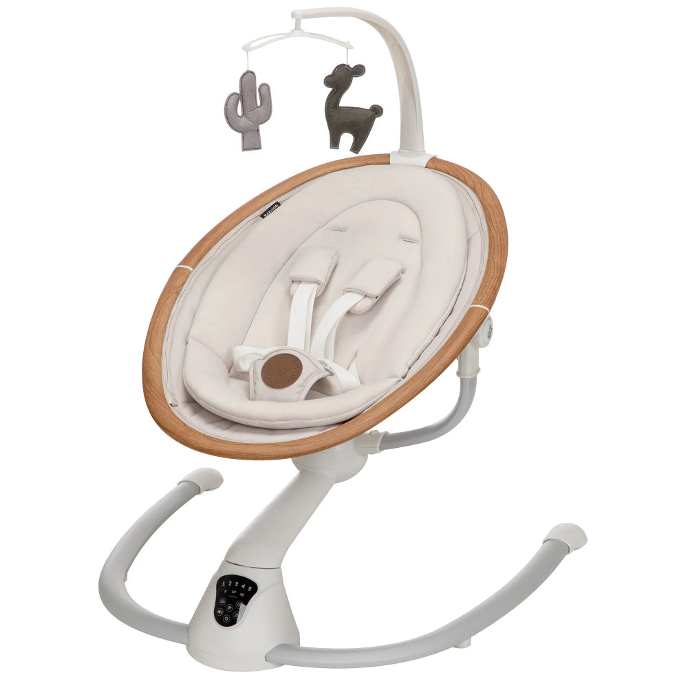 Maxi-Cosi Cassia Swing with cream padded seat and wooden rim; white frame rocks softly while plush toys dangle overhead.