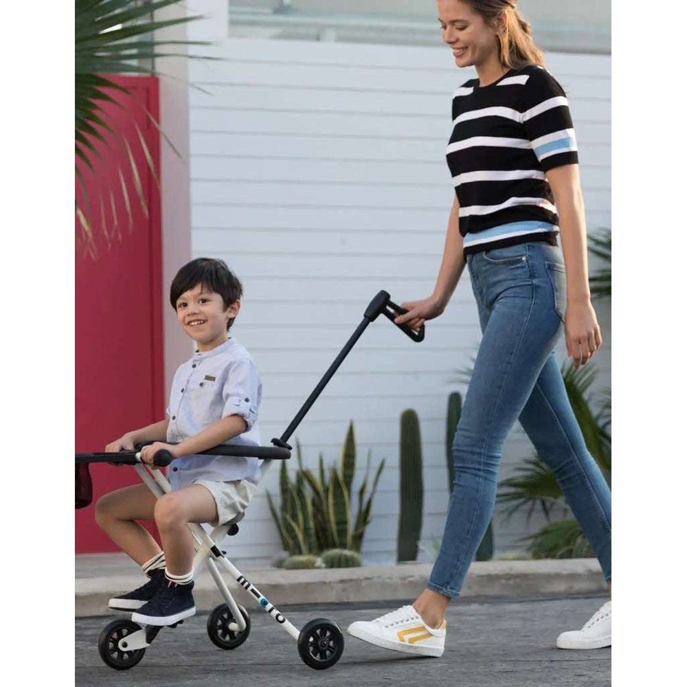 MICRO Trike Table & Loop riding toy; child sits on a silver three-wheel trike with black handles while an adult guides.