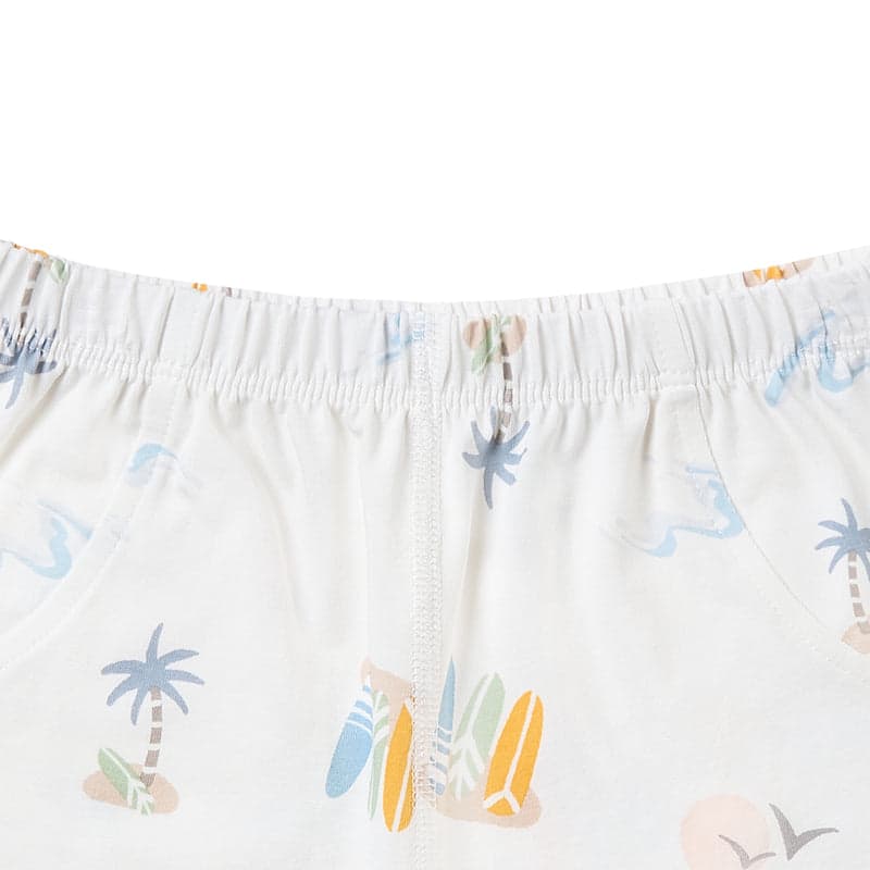 Nest Designs bamboo jersey two-piece short-sleeve baby pajama set, pastel wave print with palm motifs, elastic waistband visible.