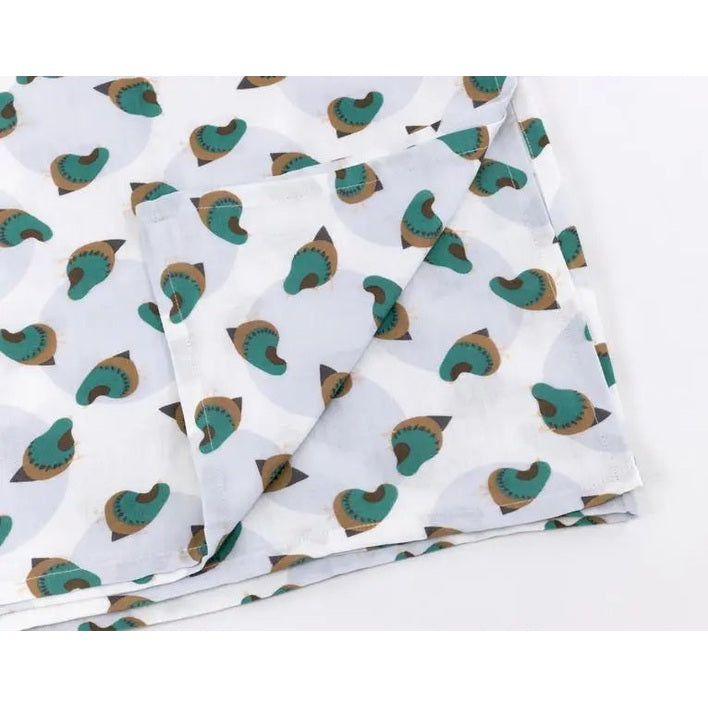 Nest Designs Bamboo Nursing Cover in white with teal and brown print, folded flat to show lightweight breathable fabric.
