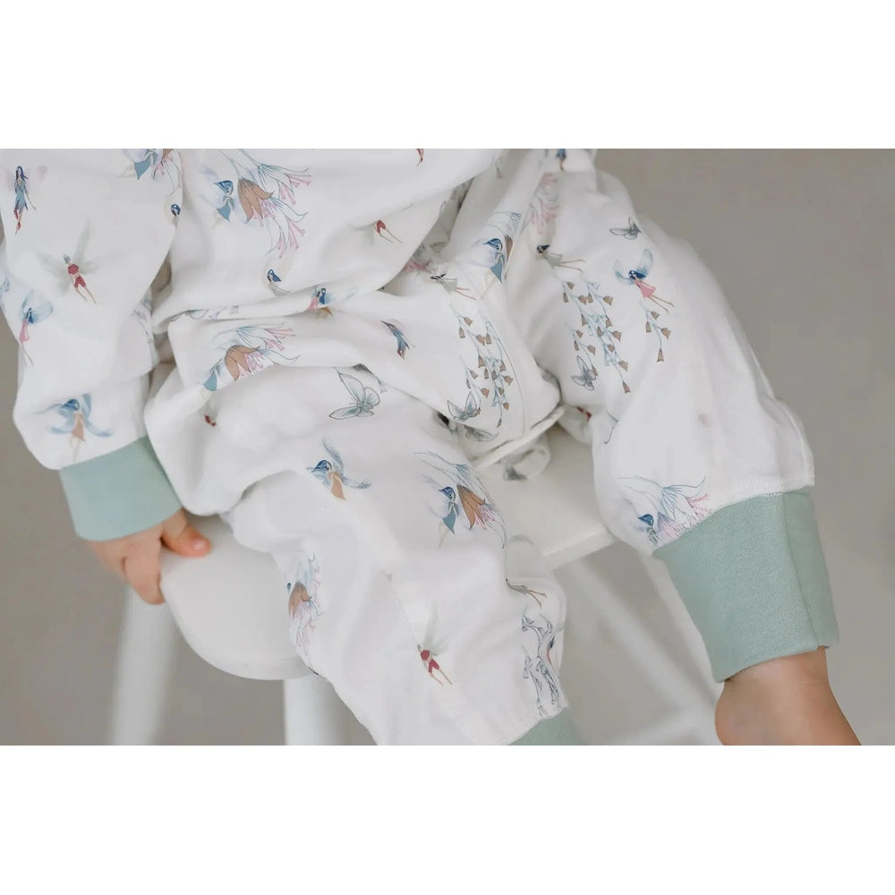 Nest Designs Bamboo Pima Long Sleeve Footed Sleep Bag 0.6 Tog Fairy Tale; baby wearing it with mint cuffs visible.