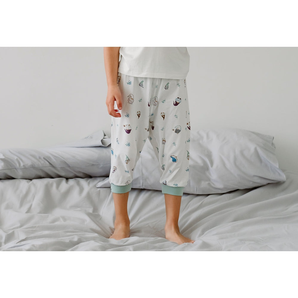 Nest Designs Bamboo Short Sleeve Play Set Oh Gnome: white top, pale gray pants with pastel gnomes, mint cuffs, child standing on bed