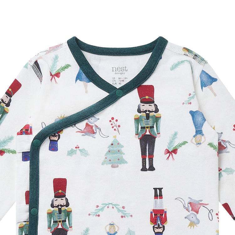 Nest Designs Organic Cotton Long Sleeve Kimono Onesie Nutcracker, baby wearing a cozy wrap-front with green trim.