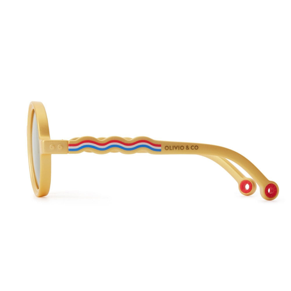 Olivio & Co round kids sunglasses in gold frame; side view shows wavy blue/red temples and logo.