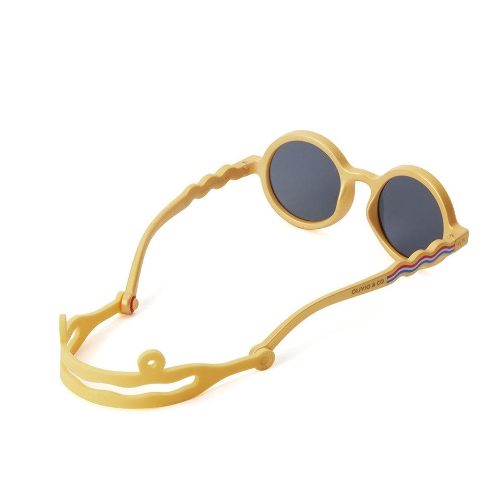 Olivio & Co Round Sunglasses Kids Medallion Gold with dark gray lenses; child-sized frame, wavy gold temples.
