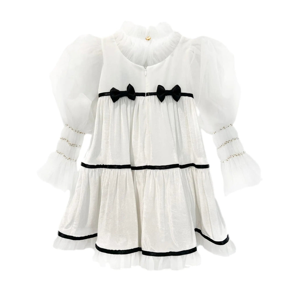 Petit Maison Kids Aurora Ivory Velour Dress with sheer puff sleeves, black ribbon bows at waist, and tiered skirt.