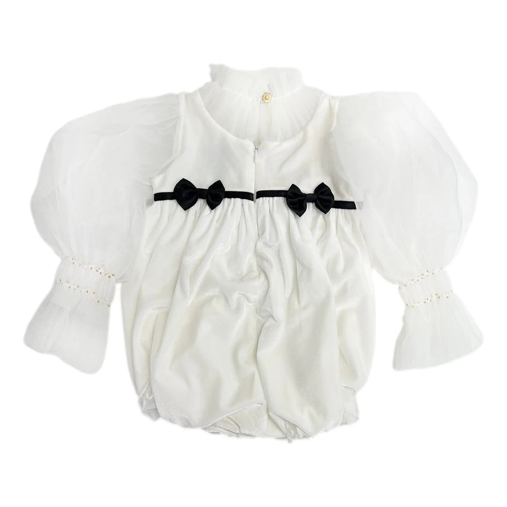 Petite Maison Kids Aurora Ivory Velour Romper laid flat; ivory velour, puff sleeves, black bow waist trim.