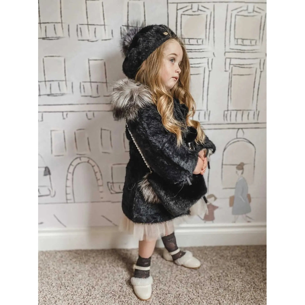 Petite Maison Kids Milana Noir beret worn by a girl posing in a plush black faux‑fur coat.