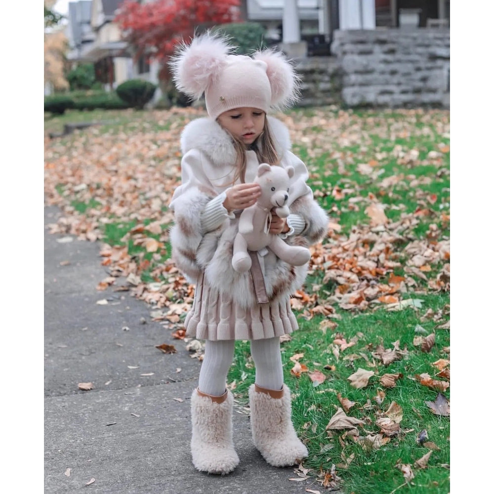 Petite Maison Kids Nikita Double Pom Angora Hat in pink, worn by a toddler who holds a plush bear.
