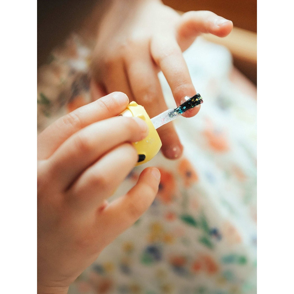 Puttisu Pangpang nail art kit candy; child paints glittery blue-green polish from a yellow bottle.
