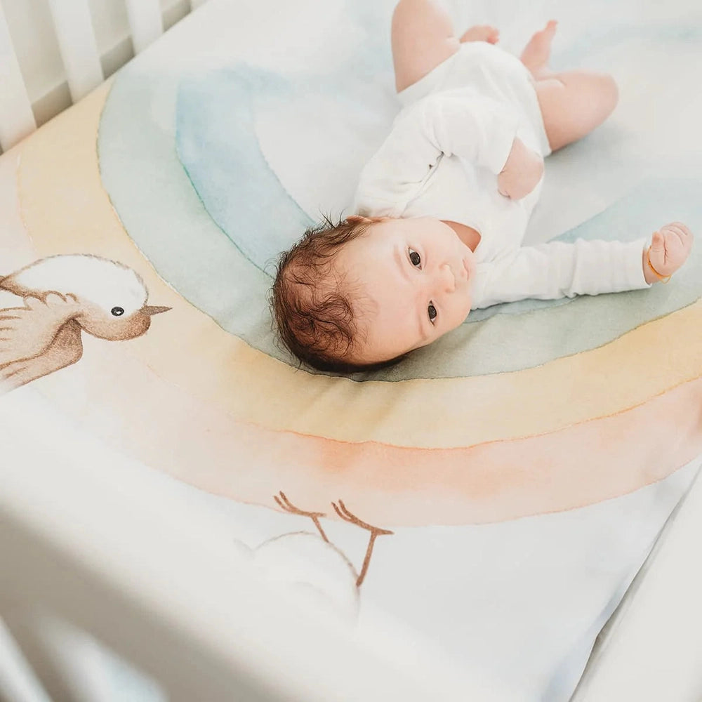 Rookie Humans crib sheet in cotton sateen with pastel rainbow and birds pattern for baby