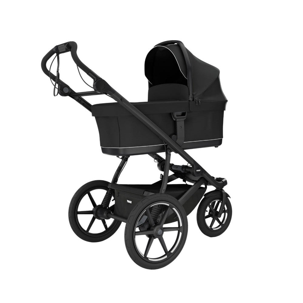 Thule Urban Glide bassinet attachment on a black stroller with canopy, THULE baby transport accessory.