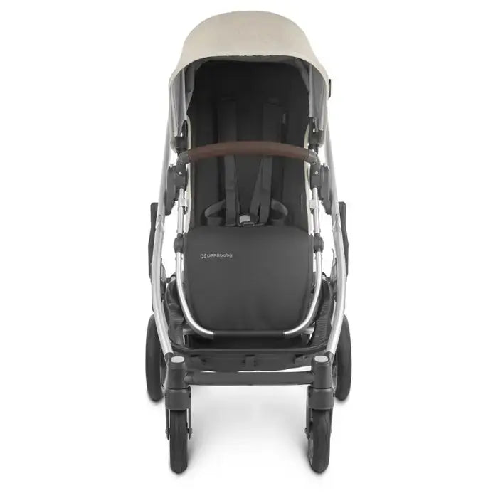 Uppababy Cruz V2 Stroller in dark gray with beige canopy, sturdy frame and brown ergonomic handlebar, front view.