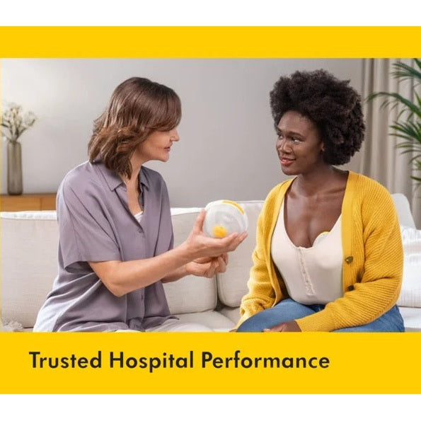 Medela Melody InBra Double Electric Breast Pump demonstrated hands-free on a cozy couch with a helper.