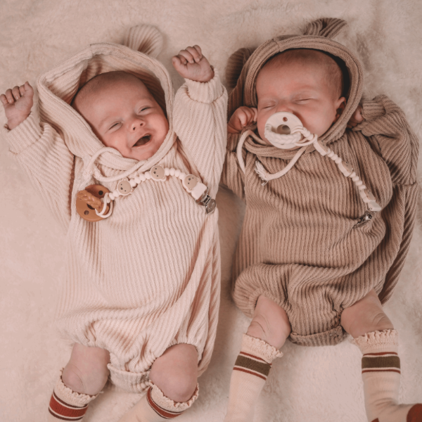 Itzy Ritzy Sweetie Strap Plus pacifier clips, cream knit outfits, two babies