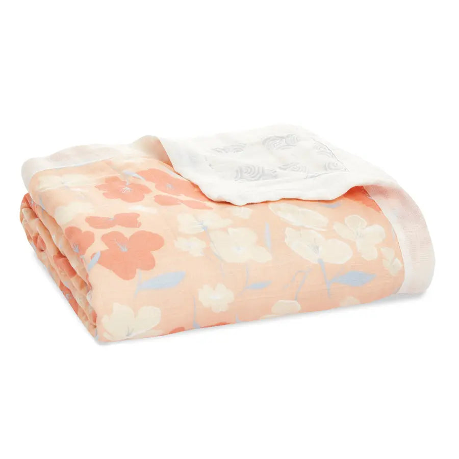 Aden+Anais Silky Soft Dream Blanket folded in peach floral pattern with a white border