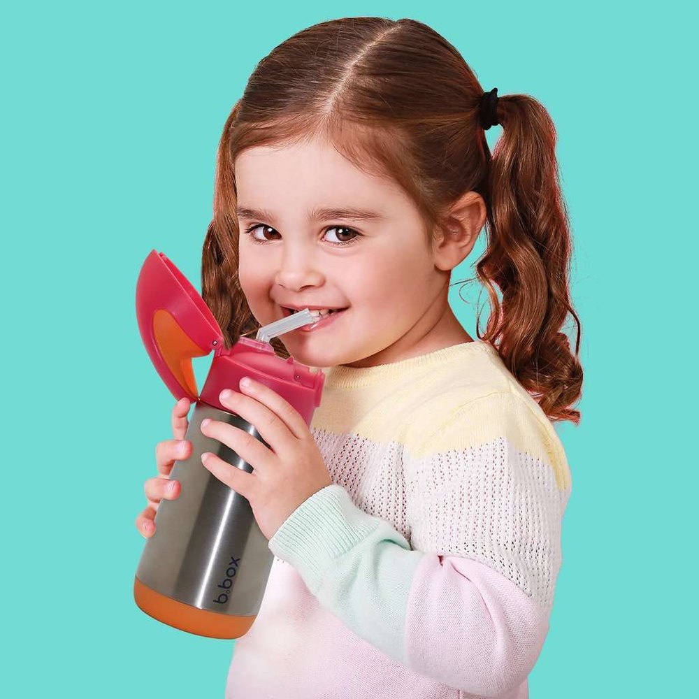 B.Box Insulated Bottle for kids with pink flip lid, gray body, orange base held by a smiling girl