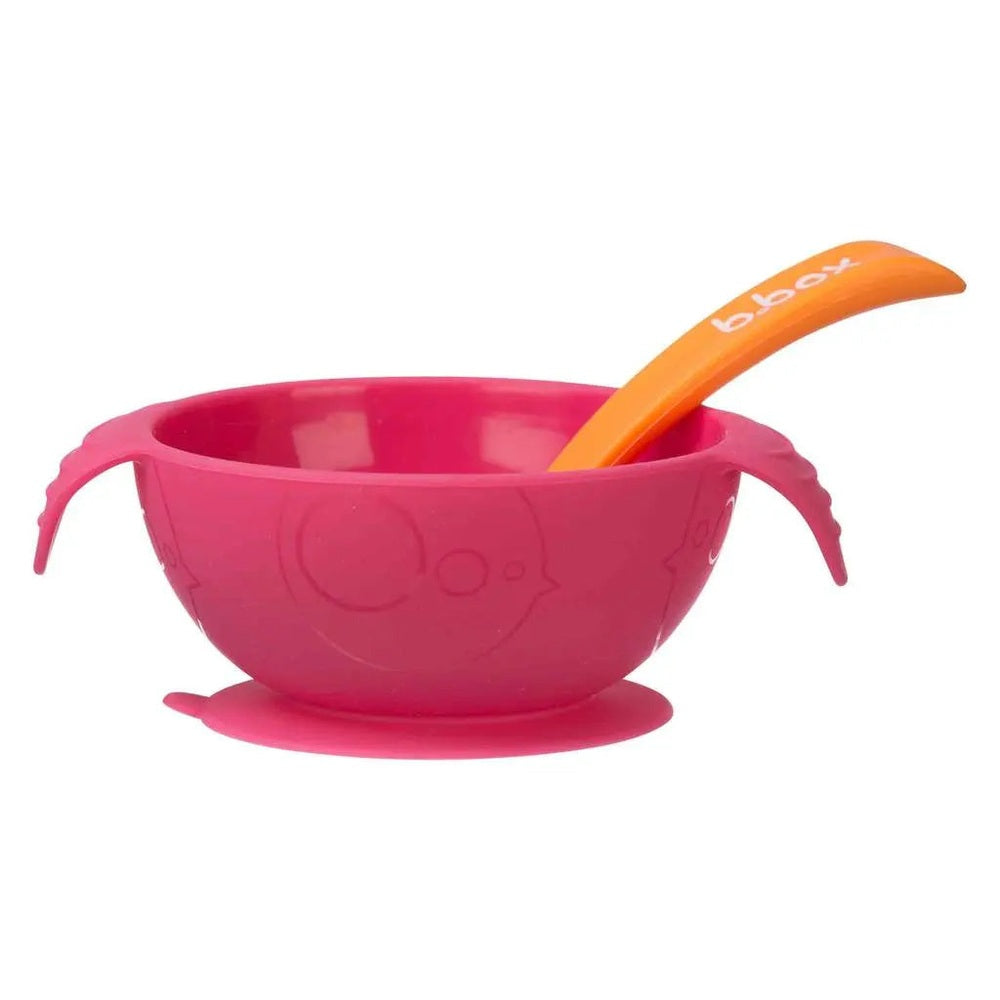 B.BOX Silicone First Feeding Set pink suction bowl with orange spoon, bowl firmly attached to tray during mealtime.