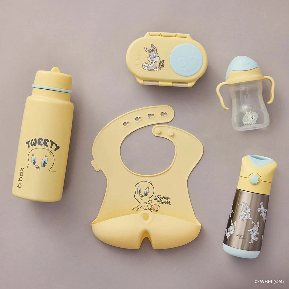 B.box Insulated Flip Top 1L bottle set in yellow with blue lid, sippy cup, and bibs arranged for mealtimes.