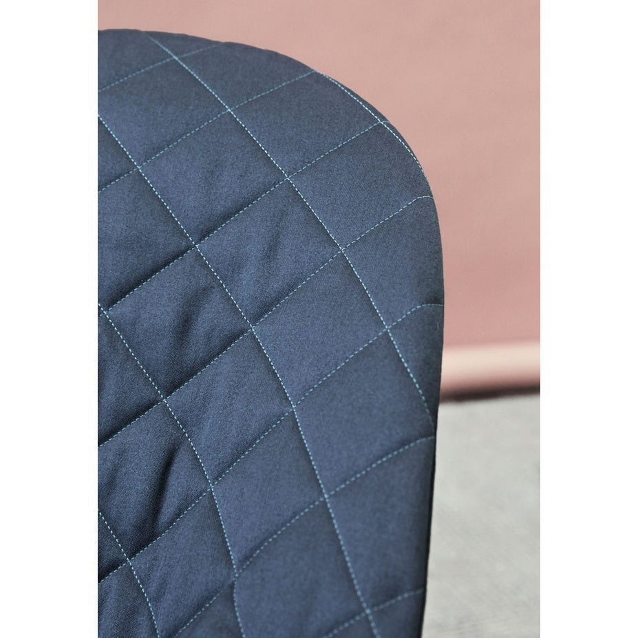 BabyBjörn Bouncer Bliss navy quilted fabric close-up showcasing a soft padded seat with grid stitching.