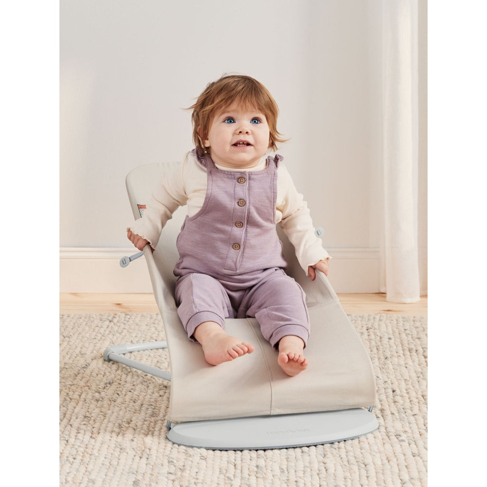 BabyBjörn Bouncer Bliss infant bouncer in beige, baby sits securely in the curved rocker.