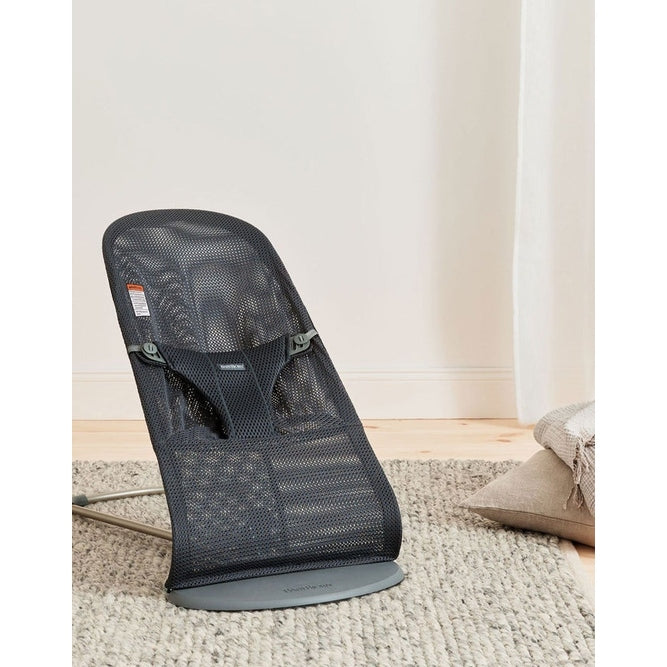 BabyBjörn Bouncer Bliss in black mesh with gray base, angled on a rug as a baby rocker.