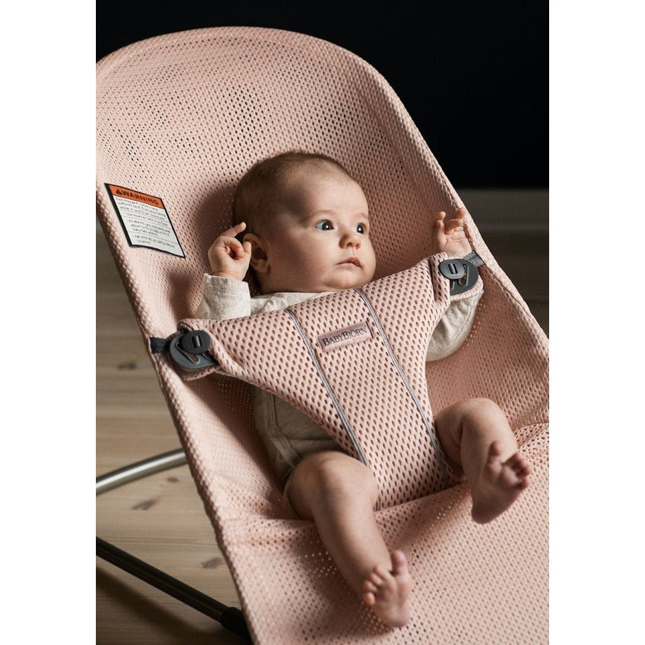 BabyBjörn Bouncer Bliss pink mesh baby bouncer; baby reclines securely in the harness with relaxed limbs.