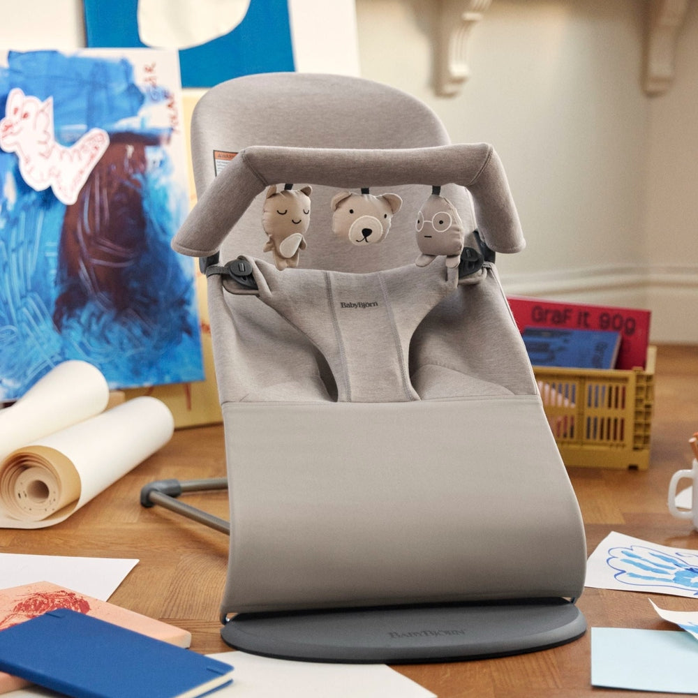 BabyBjörn Bouncer Toy in gray with plush animals hanging from a toy arch, ready for infant play.