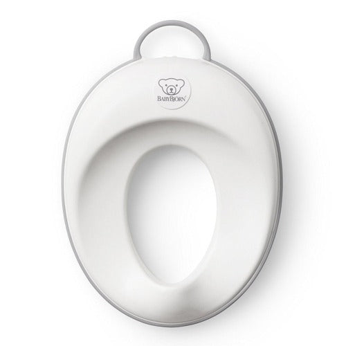 BabyBjörn Toilet Trainer seat in white with grey rim, ready for toddler potty use.