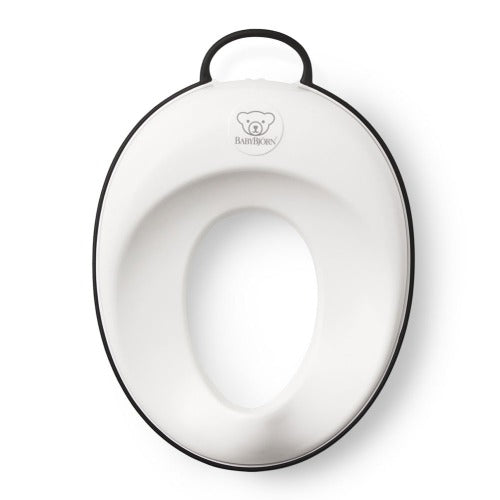 BabyBjörn Toilet Trainer in white with black edge, featuring a top handle for easy carrying.