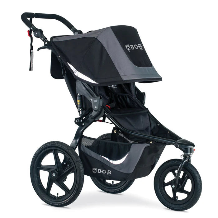 BOB Revolution Flex 3.0 Jogging Stroller in black/gray with large wheels, being pushed forward.