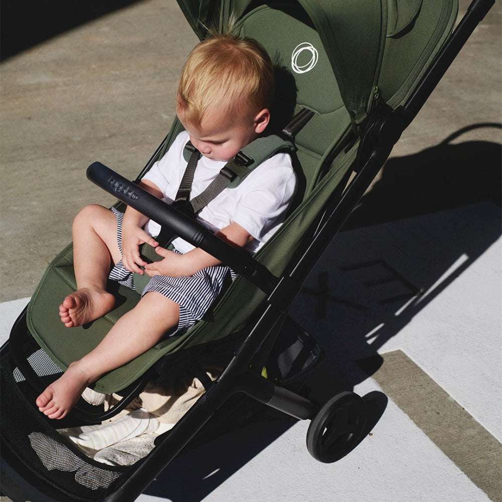 Bugaboo Butterfly 2 stroller in green with a child buckled into the harness