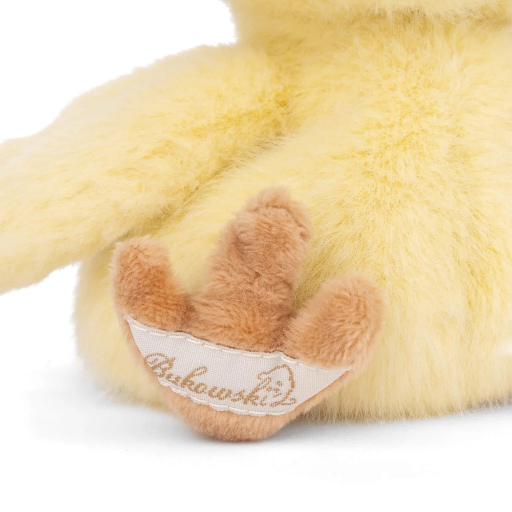 Bukowski Bears Baby Chicky stuffed toy, a fluffy yellow plush with peach feet and a white brand tag.