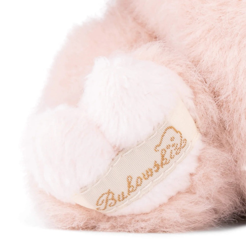 Bukowski Bears Baby Oink stuffed animal in soft pink fur with a white fluffy tail and cream ribbon label.