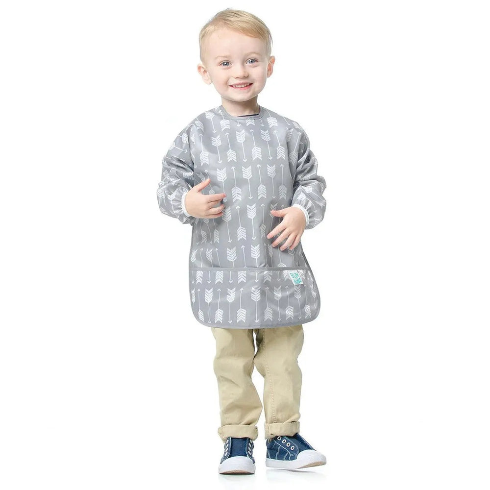 Bumkins Long Sleeved Smock Bib in grey with arrow pattern, toddler wearing it, showing full-arm coverage and front pocket.